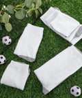 Fifteen Pairs White Sublimation Socks Blanks Made From Polyester For Easy Heat Transfer Crafting Includes Two Metal Sock Jig Inserts In Three Sizes With Gray Sole For DIY Custom Socks displayed on grass.