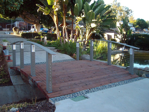 Bridge with wood deck and metal posts using Swageless Quick Connector For Cable Railings One Eighth Inch Cable Self Locking Easy Install No Caps Do It Yourself Friendly Fits Wood Metal Or Composite Posts Ten Pack.