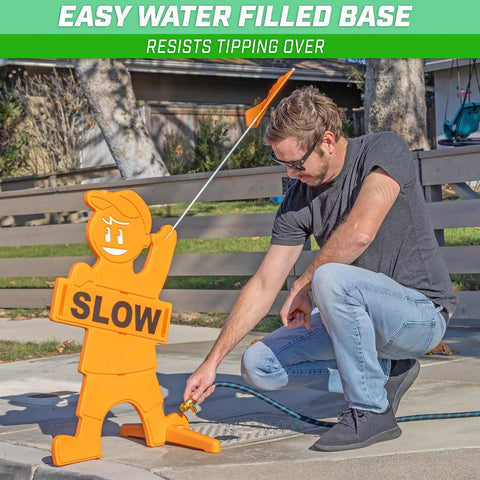 Man filling water base of Kids At Play Street Safety Sign With High Visibility Neon Orange Design, All Weather Durability, Includes Warning Flag To Slow Down Drivers And Keep Pedestrians Safe.