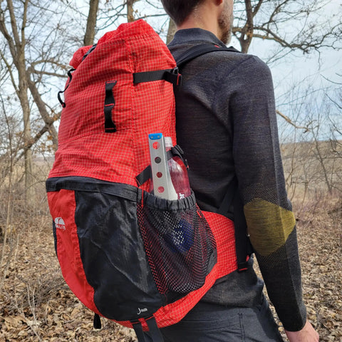 Ultralight Backpacking Trowel 0.48 Oz 13.5 G Blue With Lifetime Warranty in mesh pocket on red hiking backpack.