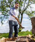 Man chopping wood wearing HydraHyde Leather Work Gloves For Ranching, Fencing And Construction, Water Resistant Split Cowhide.