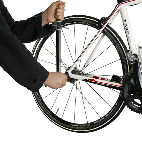 Person using Rear Derailleur Hanger Alignment Gauge For Precise Drivetrain Tuning And Noise Reduction on a bike wheel