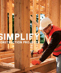 Construction worker using a hammer at a building site, wearing safety gear, highlighting simplification of construction projects.