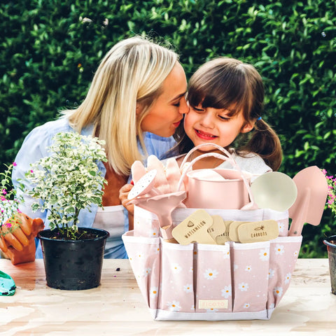 Mother and daughter using Kid Friendly Garden Starter Kit With Durable Safe Tools For Outdoor Fun Including Gloves, Tote Bag, and labels.