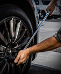Extended 30 Inch Breaker Bar With One Half Inch Drive used on car wheel lug nut for leverage, Chrome Vanadium shaft visible.