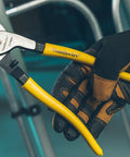 Tough Nine Inch Cable Cutter With Comfort Dipped Grips And Solid Forged Steel Arms used for fast wire snipping in a gloved hand.