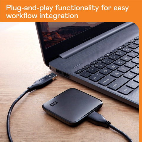 2TB Portable SSD With USB 3 For Quick File Transfers On The Go connected to laptop, showcasing compact design and plug-and-play feature