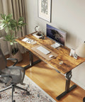 Electric Standing Desk 48 By 24 Inch with Quiet Lift Memory Presets, rustic brown finish, in a home office setting with chair and plants.