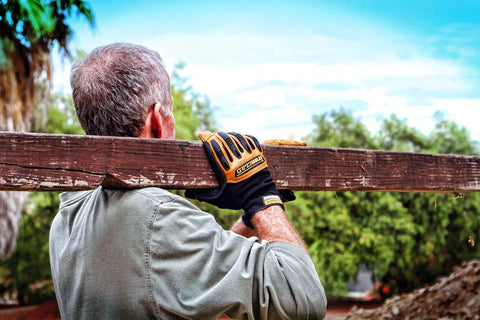 Man carrying wood wearing Rugged Rolltop Seamless Fingertips Leather Work Gloves With Kevlar Reinforcements For Maximum Dexterity And Durability