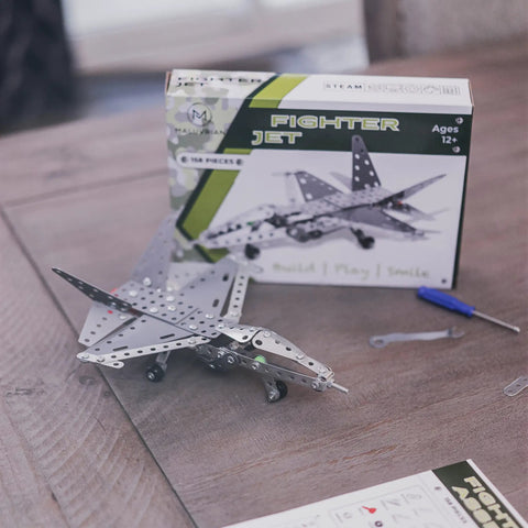 Build Your Own Fighter Jet Erector Set Metal Model Airplane Kit with box and tools on wooden table