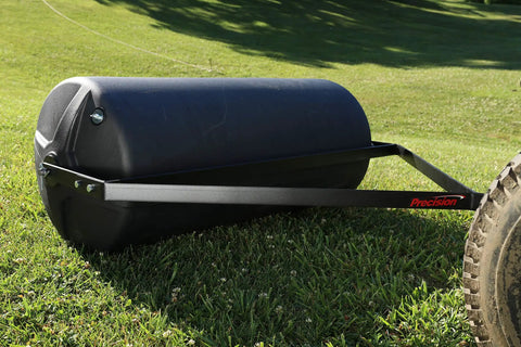 18-Inch by 36-Inch tow behind lawn roller in use on grass, heavy duty poly roller with 40 gallon capacity, side molded spokes visible
