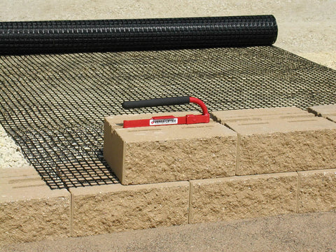 Versa-Lok Versa Lifter Standard Tool For Easy And Safe Handling Of Block Walls on concrete blocks and mesh background.