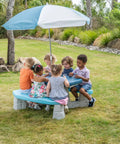 Kids playing at Sun And Fun Picnic Table With Umbrella For Indoor And Outdoor Use Toddler Sized Table With Five Foot Shade Canopy