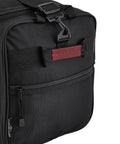 Travelers Club 32-inch expandable rolling travel duffel bag, side view; black with red accent strap and front mesh pocket