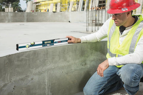 Worker using GIM 60 24 Inch Digital Level With Illuminated Rotating Display And Auto Rotating Screen for precise measurements on concrete