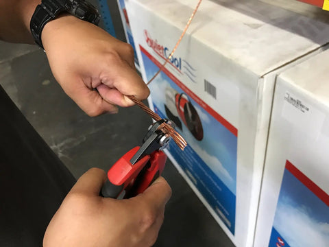 Person using 7 Inch Wire Rope Cutter For Railing And Cable Installations With Induction Hardened Blades on copper wire