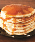 Round Cast Iron Griddle Pan 10.5 Inch Pre Seasoned Non Toxic PFAS Free Cookware with pancakes topped with syrup