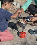 Family cooking with Go To Solo Camping Pot 1.3 Liter With Nonstick Ceramic Fusion Coating on a portable stove outdoors.