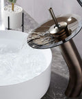 Waterfall Bathroom Faucet With Single Handle Solid Brass Construction Oil Rubbed Bronze Finish pouring into white vessel sink.