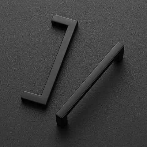 Top view of two Twenty Five Pack Solid Zinc Slim Square Bar Cabinet Pulls With Three And Three Quarters Inch Center To Center Matte Black Kitchen Drawer Handles Premium Quality Finish Sturdy Construction For Daily Kitchen Use on a dark surface.