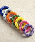 Multi-color spiral DEET Free Mosquito Repellent Bracelets For Kids And Adults, 15 Pack on beige background