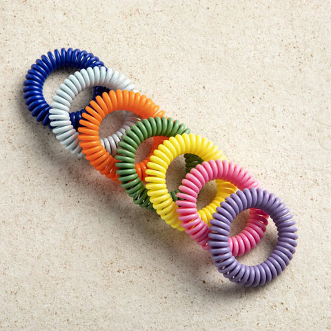 Multi-color spiral DEET Free Mosquito Repellent Bracelets For Kids And Adults, 15 Pack on beige background