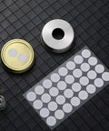 Sheet of 128 Pieces Synthetic Filter Paper Discs for Mushroom Cultivation, 20 mm Diameter, shown with wide mouth jar lids.