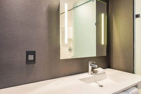 Adorne Tamper Resistant Self Test GFCI Outlet 15A Magnesium Finish With Matching Wall Plate in modern bathroom setting