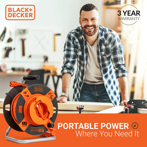 Man in workshop with 50 Ft Outdoor Extension Cord Reel With 14 AWG SJTW Cable, Heavy Duty Rewind Handle, Premium Cord Retractor.