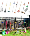 Back Saver Tool Handle Attachment for Shovels and Rakes in garden; ergonomic offset grip on long-handled tools against a fence.