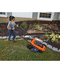 Person using a 20 Inch Corded Electric Lawn Mower With 13 Amp Motor Ultra Light No Sweat Push Design near garden edges