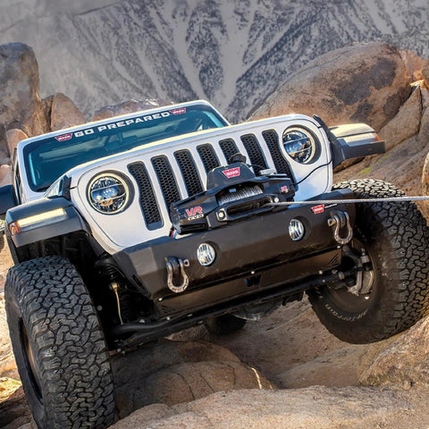 Warn Vro Evo 10 Standard Duty 12V DC Electric Winch With Steel Rope on a Jeep overcoming rocky terrain.
