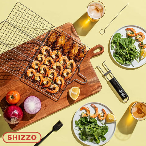 Top view of stainless steel Shallow Grill Basket Set for outdoor grilling with shrimp, vegetables, skewers, and basting brush on table.