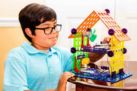 Child constructing with Elenco My Home Electronics Building Kit For Kids Aged 8 And Up With 34 Hands On STEM Projects And Color Coded Blocks