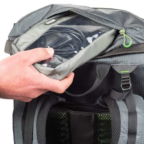 Hand accessing cable pouch in Rotating 50L Plus Camera Backpack For Epic Adventure Photography With Front Access, Tripod Carry.
