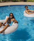 Two adults enjoying Motorized Pool Tube Float For Adults Pro 3.0 With 66W Motor Joystick Steering Phone Holder in the pool.
