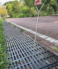 Built Tough Stainless Steel Manhole Cover Hook With Triangular Handle Portable Heavy Duty Sewer Lid Lifter in use on drain grate.