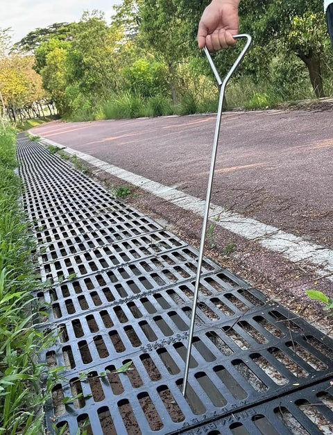 Built Tough Stainless Steel Manhole Cover Hook With Triangular Handle Portable Heavy Duty Sewer Lid Lifter in use on drain grate.