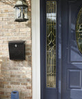 Locking Wall-Mounted Mailbox in Rubbed Bronze next to a blue door, Galvanized Steel Outdoor Mailbox with Secure Drop Box