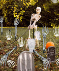 Outdoor Halloween scene with 18 Piece Realistic Skeleton Arm Stakes and Hands Set among tombstones and pumpkins on lawn.