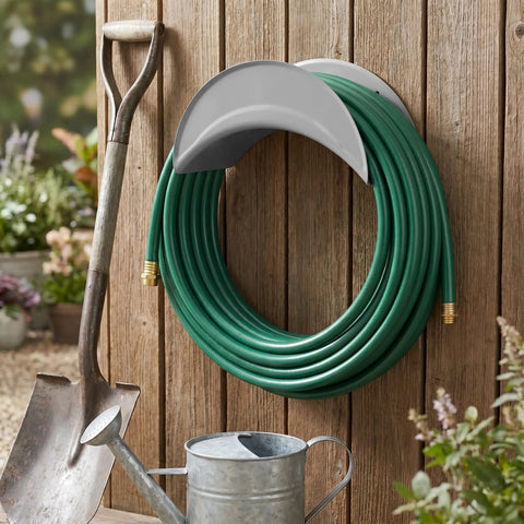 Heavy Duty Wall Mount Hose Hanger 2 Pack Sturdy Iron Metal Rack holding green garden hose on wooden wall with tools.