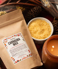 Straight Up Pure Carnauba Wax Flakes For Smooth Skin Care And Lip Balm Making Real Deal Vegan Candle Wax With Leather And Wood Finish Must Have DIY Staples Eight Ounce Bag with yellow wax flakes and candle.