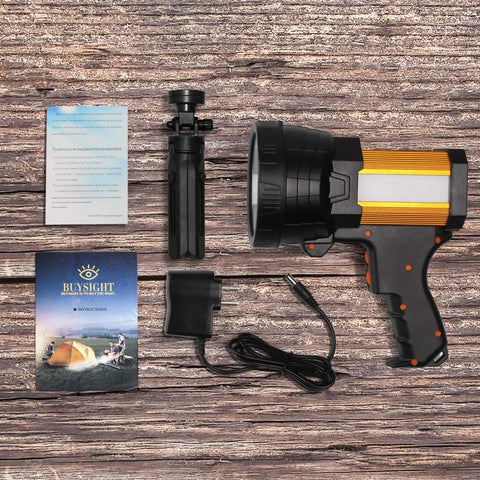 Rechargeable Spotlight Beast With 2,000,000 Lumens Handheld Large Flashlight and accessories on wooden surface