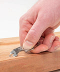 Hand using DoohicKey Keychain Multi Tool Stainless Steel 8 In 1 Bottle Opener Nail Puller Wrench on wooden surface