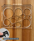 A Damn Sharp Transparent Acrylic Router Template For Woodworking Boasts Thirteen Circle Sizes Packed In A Single Piece on wood background.