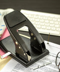 2 Hole Padded Punch For Office Use, Medium Duty, 50 Sheet Capacity, Ergonomic Padded Handles, Adjustable Guide, Black on office desk