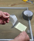 Screen Repair Patch Kit With Fiberglass Mesh And Strong Adhesive For Window And Door Screens being applied to a screen frame