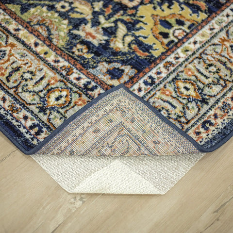Non Slip Rug Pad Gripper for Area Rugs 1 Foot 6 Inch By 2 Foot 6 Inch Ultra Low Profile under a blue patterned rug corner.