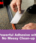 Person using No Residue Duct Tape 1.88 Inch By 20 Yards Grey 2420A to secure cords on carpet with clean removal adhesive