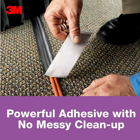 Person using No Residue Duct Tape 1.88 Inch By 20 Yards Grey 2420A to secure cords on carpet with clean removal adhesive
